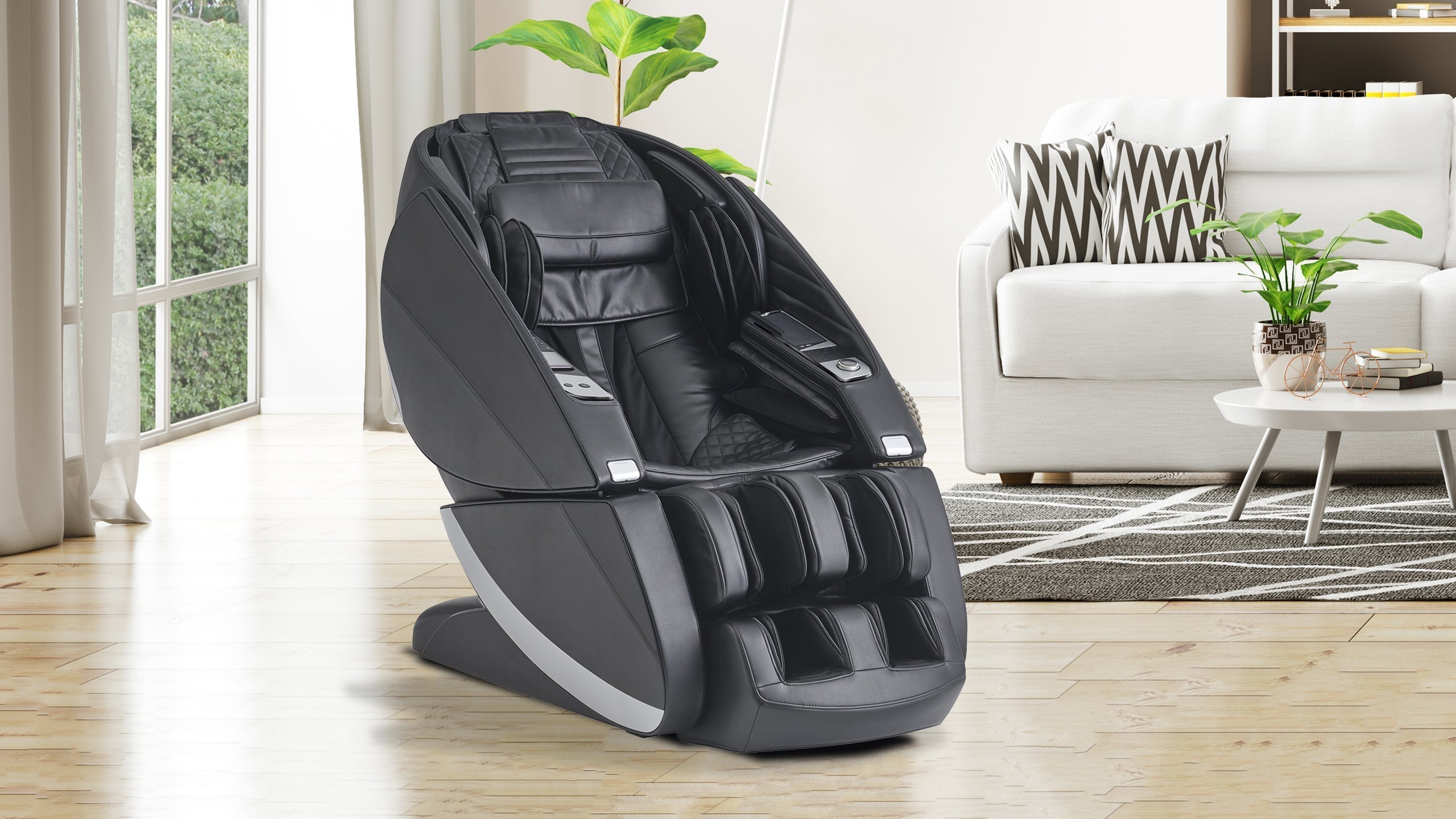 Black full-body massage chair with gray base in a bright living room with a white sofa and indoor plants