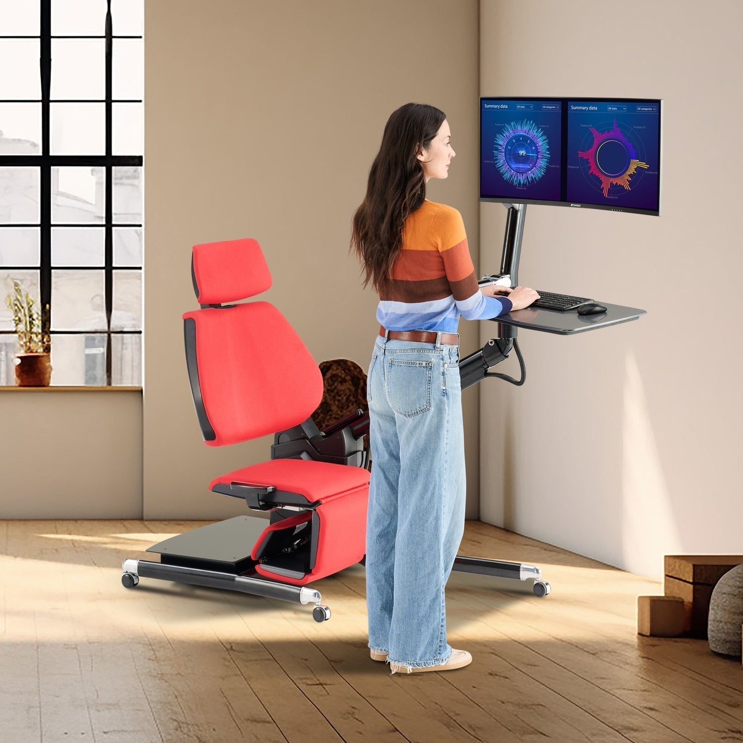 Woman working at a dual monitor standing desk setup beside a red ergonomic recliner chair in a modern home office