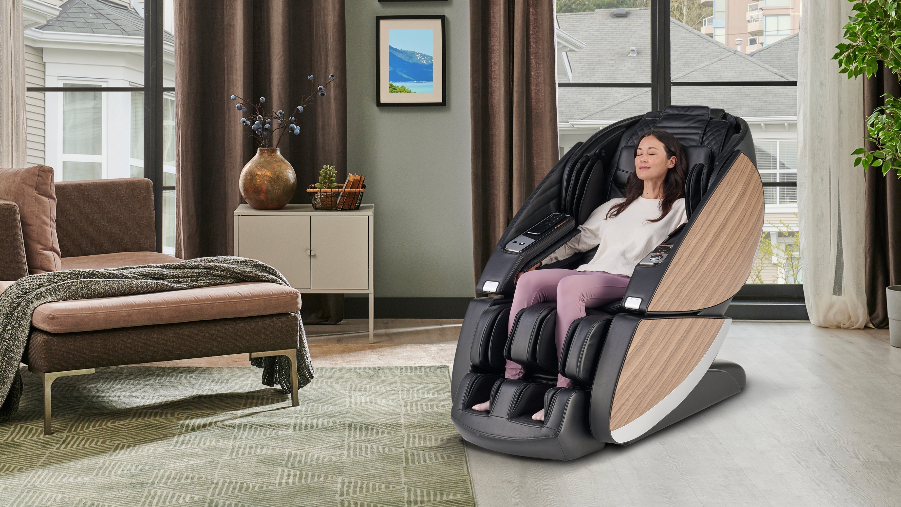 Woman relaxing in black leather full body massage chair with wood panel sides and foot rollers
