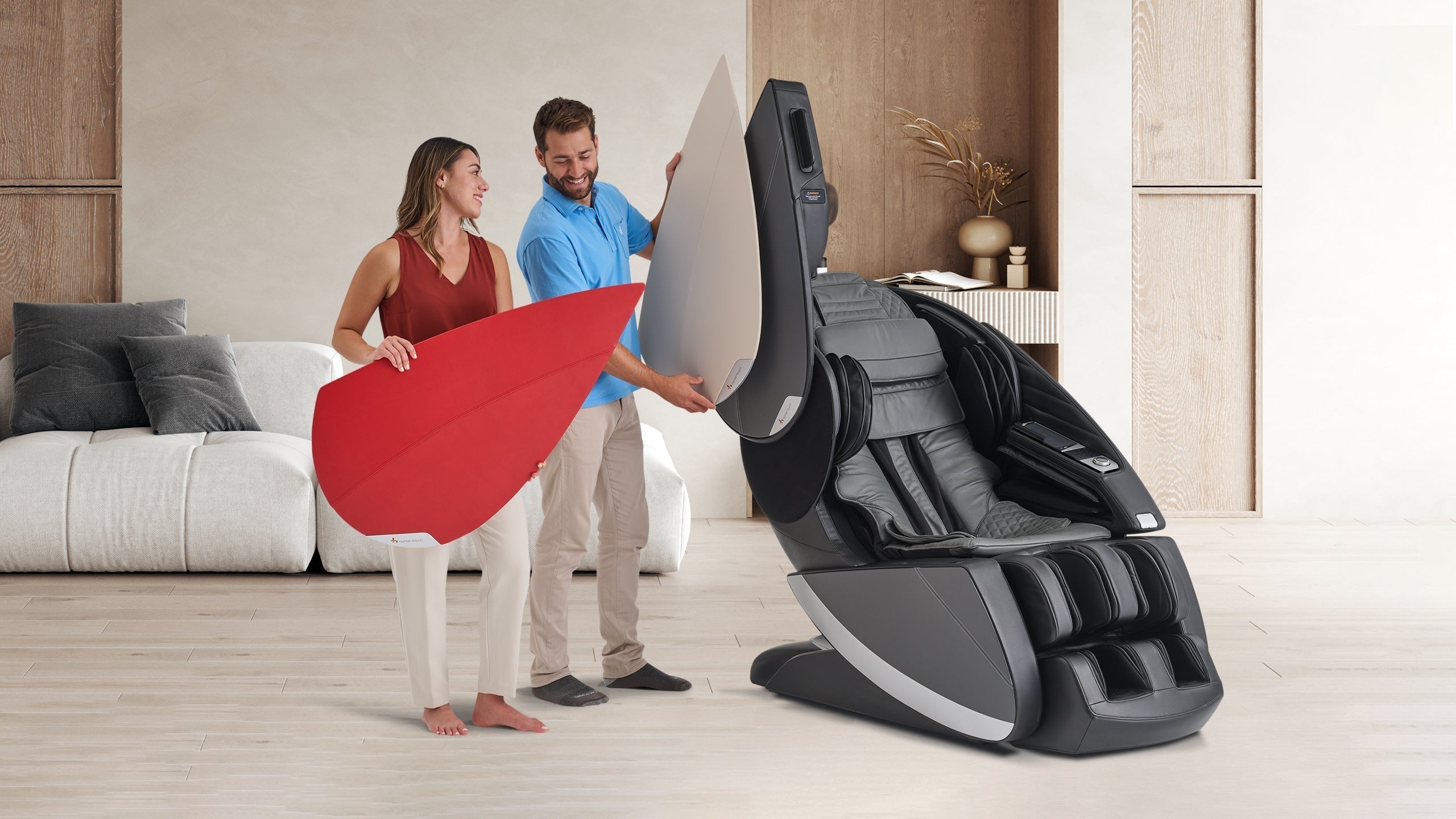 Couple unboxing black and gray full body massage chair with calf foot rollers and touchscreen panel