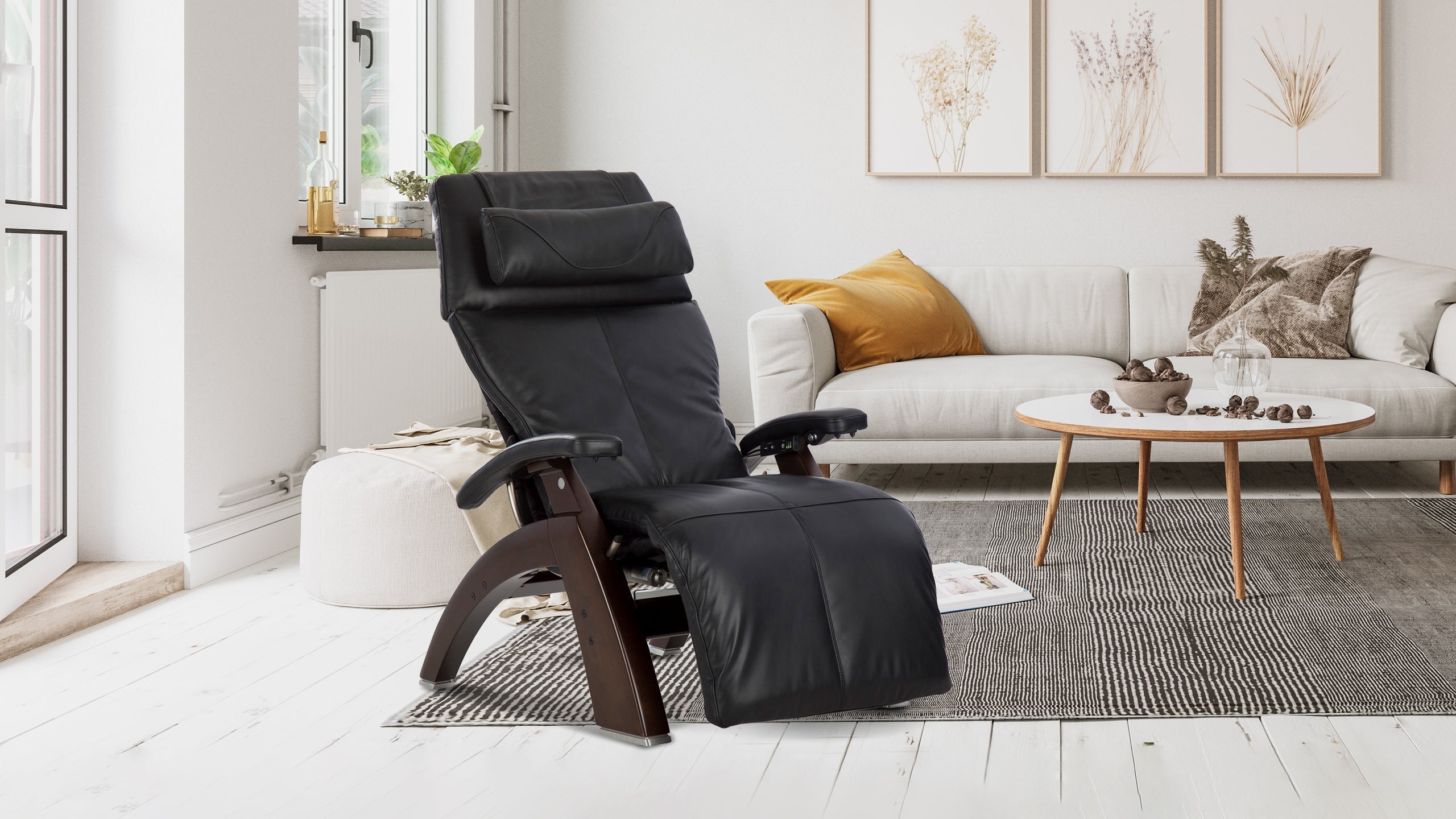 Black leather zero gravity recliner chair with curved walnut wood frame in a bright Scandinavian style living room