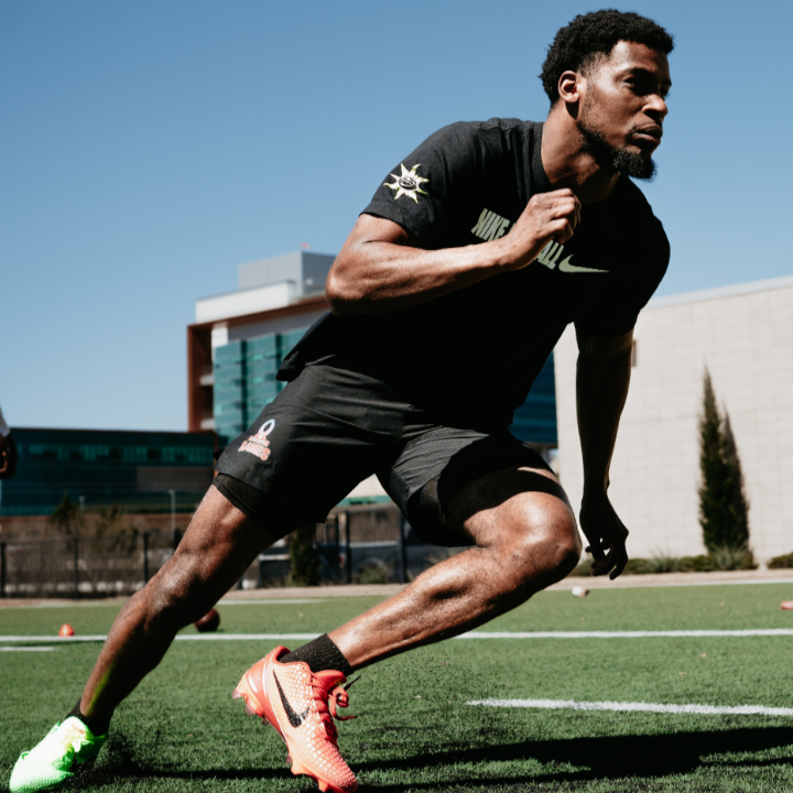 Devon Witherspoon running on a sports field with another person in the background