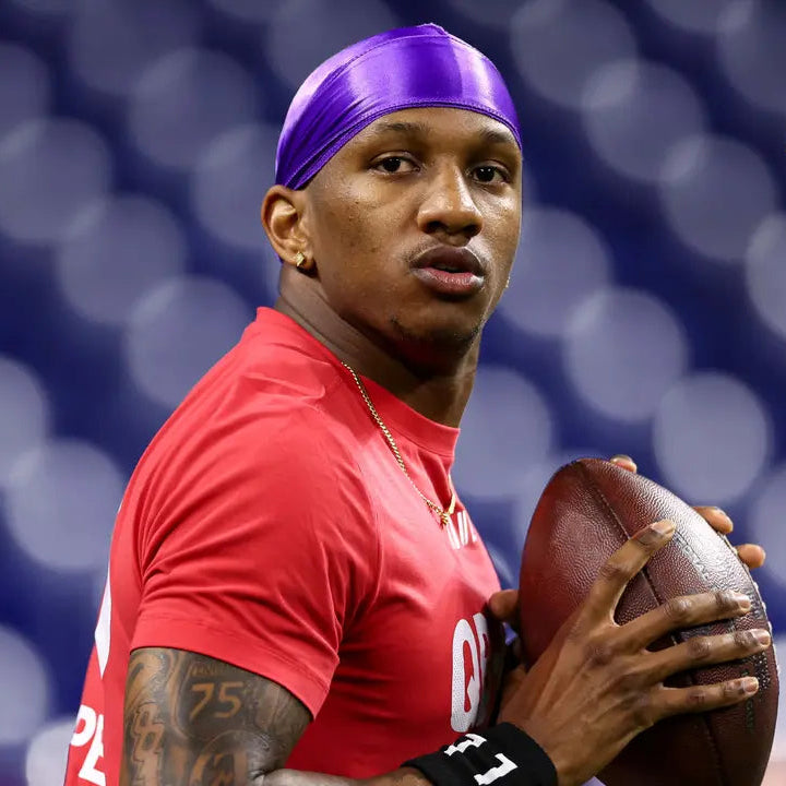 Michael Penix Jr in red shirt holding a football