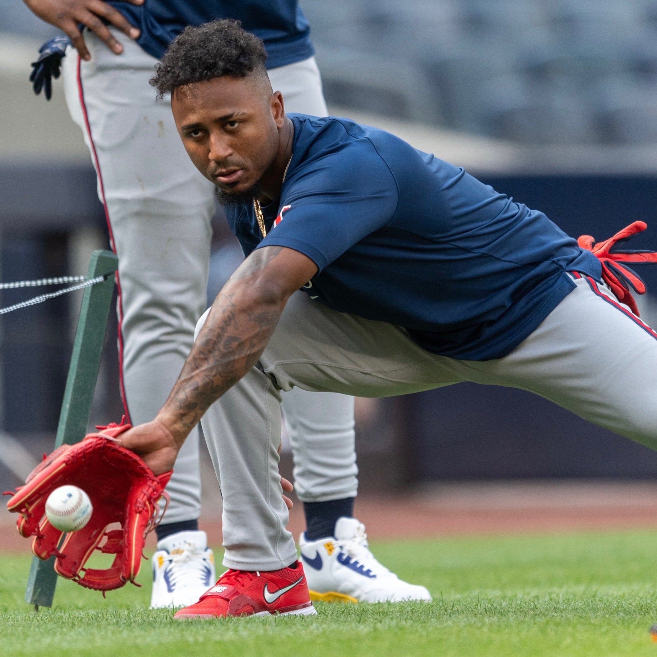 Ozzie Albes in a blue shirt and red gloves preparing to catch a ball on a field.