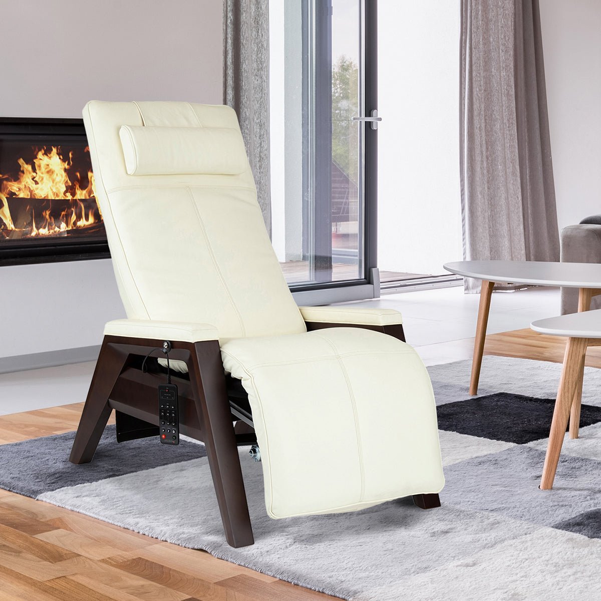 Gravis ZG Chair in cream leather, positioned in modern living room with fireplace, showcasing zero-gravity recline feature