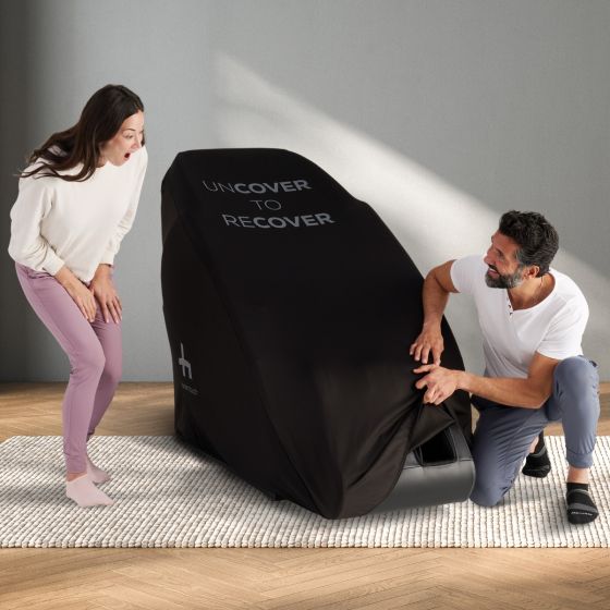 Massage Chair Cover: Protective black furniture cover being demonstrated on luxury massage chair on hardwood floor