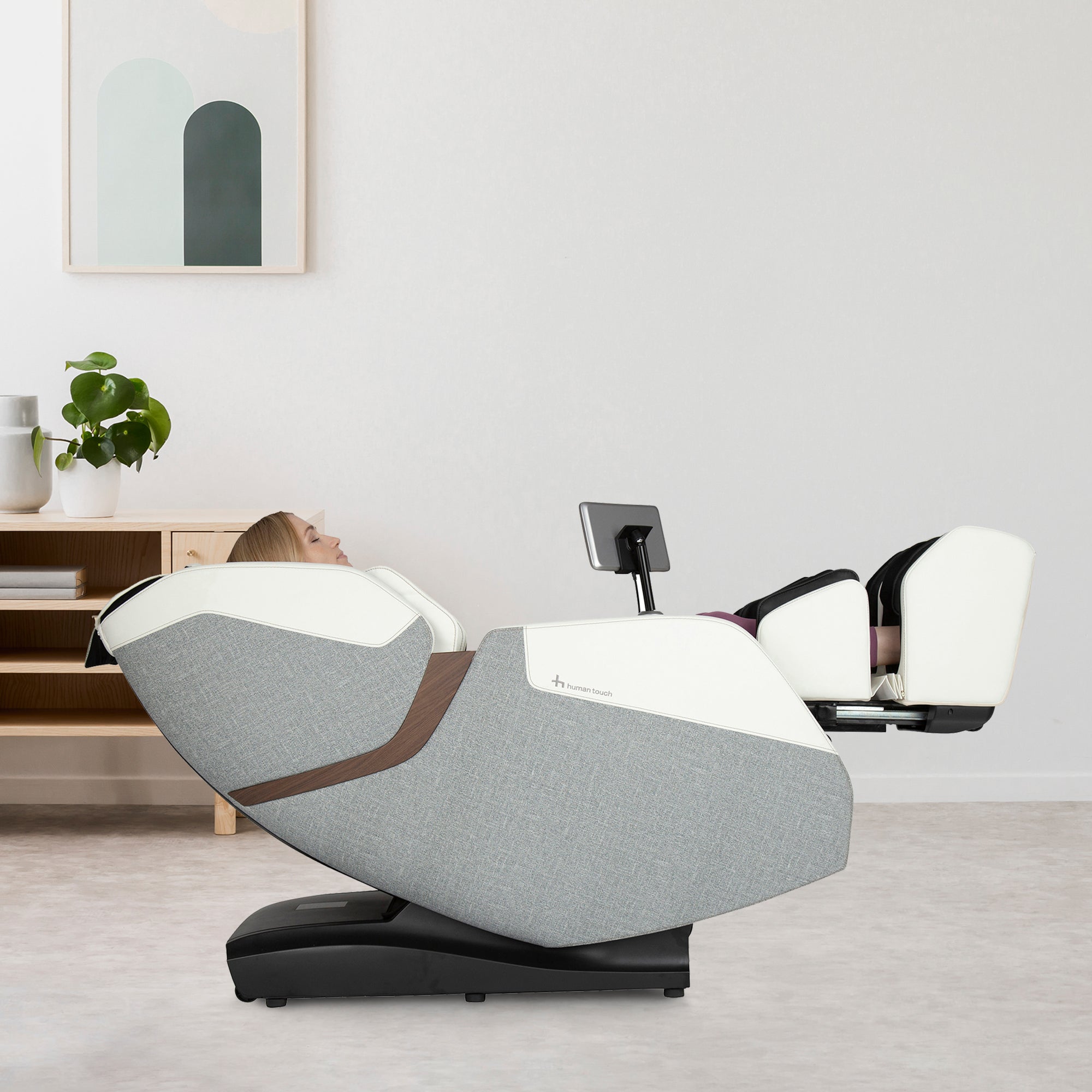 WholeBody ROVE massage chair in grey and white, shown reclined in a minimalist living room with modern decor