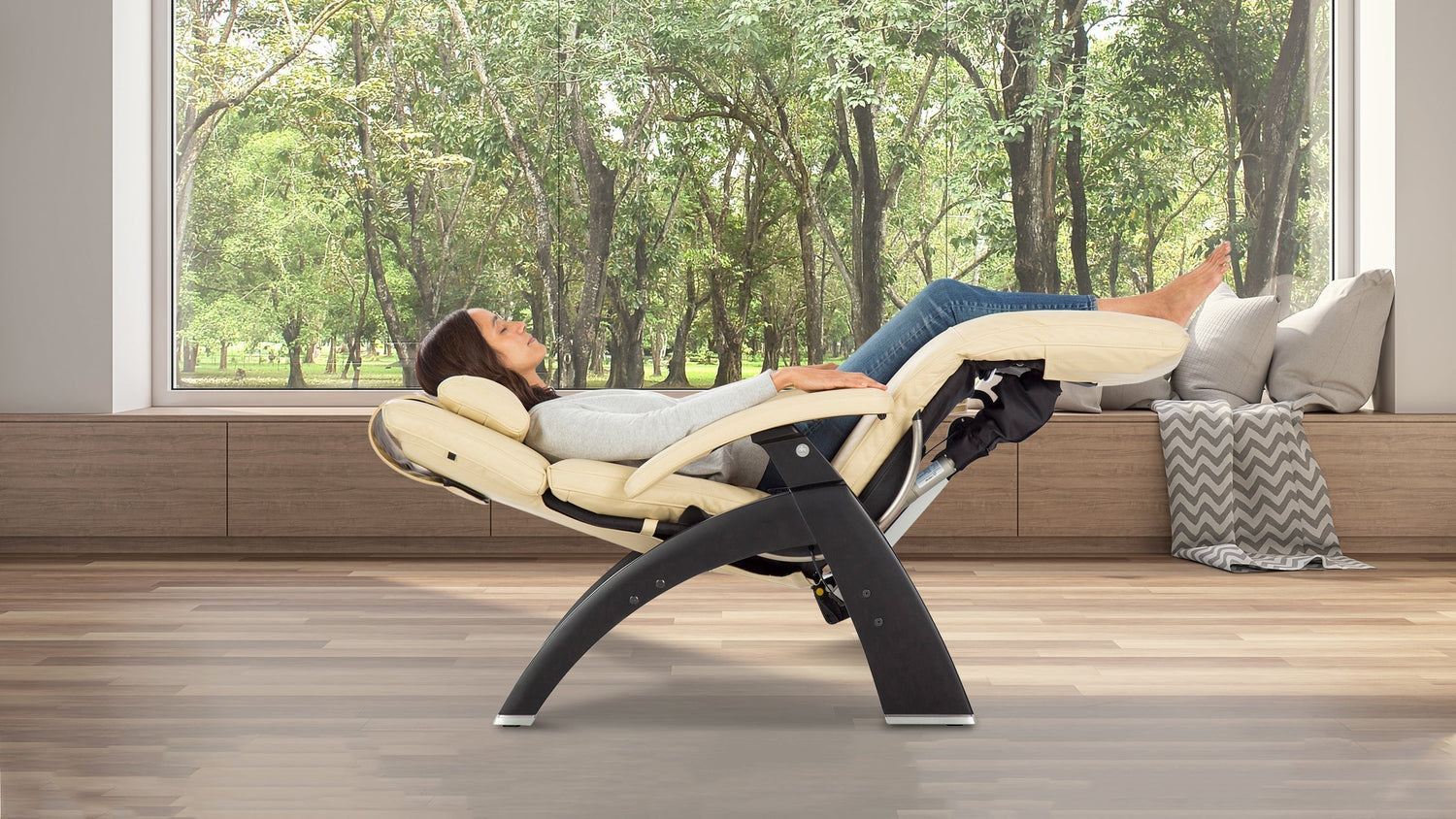 Woman reclining in a zero-gravity chair with her legs elevated in front of large windows
