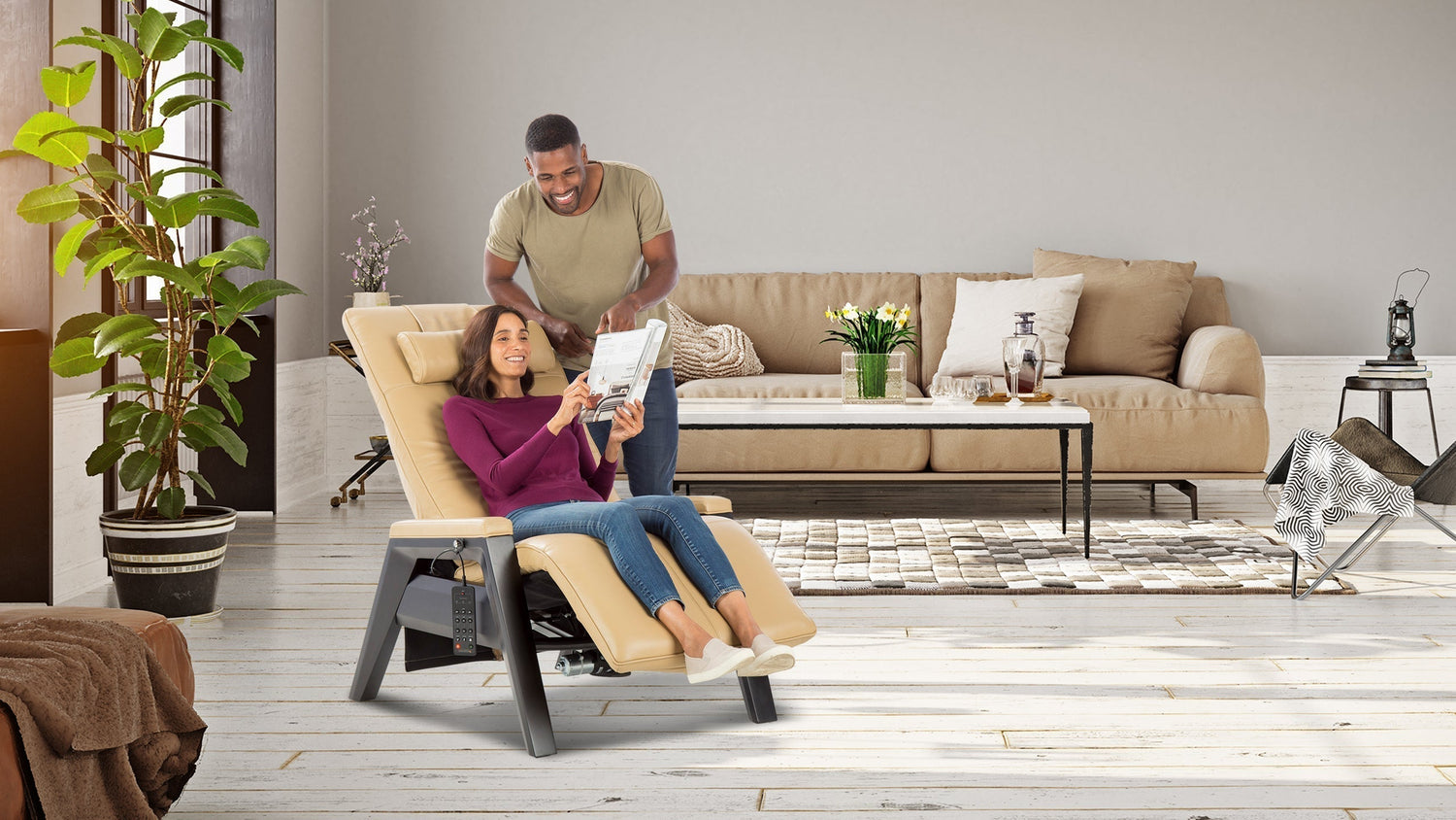 Woman relaxing in a reclining wellness chair while reading as a man stands beside her in a living room