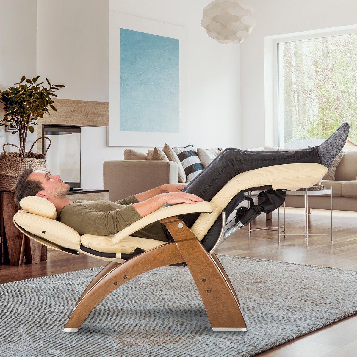 Perfect Chair PC-610 Omni-Motion Classic shown in zero-gravity position with person relaxing in cream leather recliner